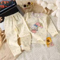 Children's outfit with Hello Kitty design on a textured surface next to a laptop.