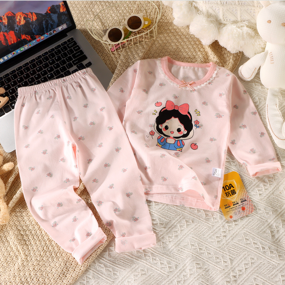 Children's pink pajama set with cartoon character on a textured surface.