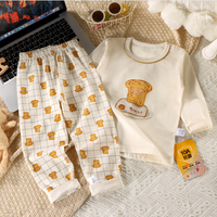 Children's pajama set with bread design on a textured surface